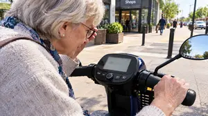 Senior Woman Rider Checking Scooter Display