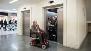 A Senior Lady Rider on Her Mobility Scooter Waiting for the Lift